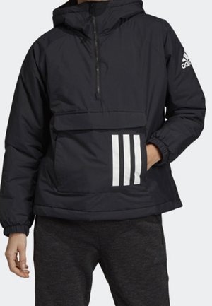 Persoon draagt een zwarte Adidas-hoodie met een voorzak met drie witte strepen en het Adidas-logo op de mouw.