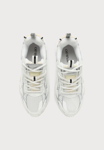 Ζευγάρι λευκά sneakers της μάρκας Off-White με πάνελ από δίχτυ και δέρμα, μαύρες και λευκές ριγωτές θηλιές και κορδόνια, προβεβλημένα από πάνω.