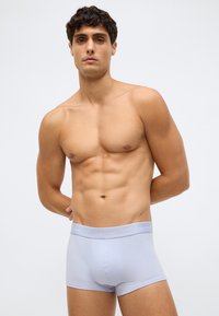 Pánské boxerky Calvin Klein v světle modré barvě, s logem na pase, vyrobené z hladkého bavlněného směsi, s bezešvým designem a těsným střihem.
