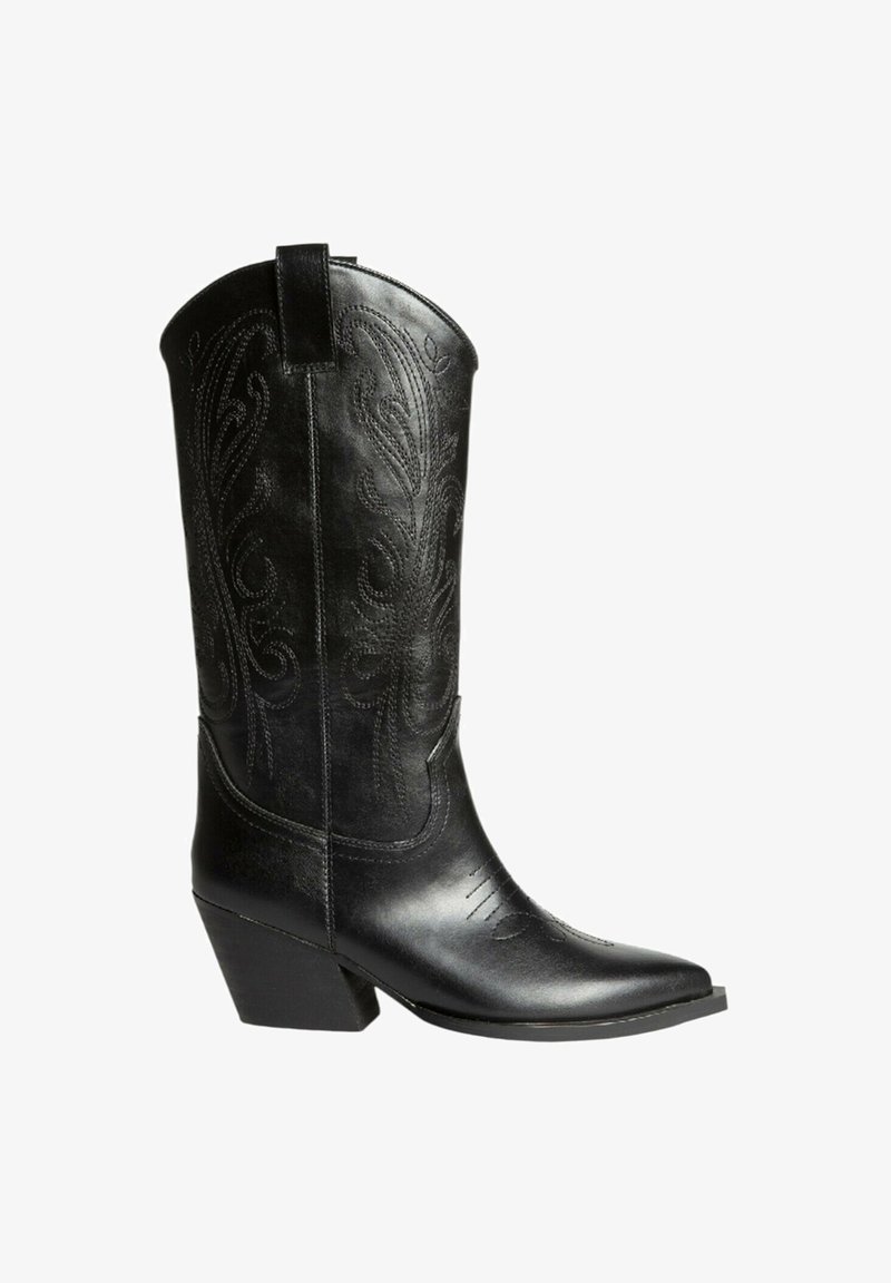 Bota de vaquero de cuero negro con punta afilada, patrones florales en relieve y un tacón bajo y apilado. Presenta costuras sutiles y un caña alta.