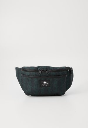Black patterned fanny pack with two zippered compartments, adjustable strap, and Lacoste logo. Features a geometric design texture.