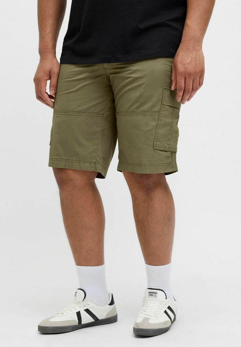 Olive green cargo shorts featuring a straight cut, multiple pockets, and a durable cotton fabric, paired with white socks and sneakers.
