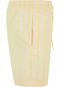 Shorts jaunes clairs avec des rayures verticales d'une teinte plus foncée. Ceinture élastique avec cordon de serrage, dotée d'une poche latérale. Texture de tissu lisse.