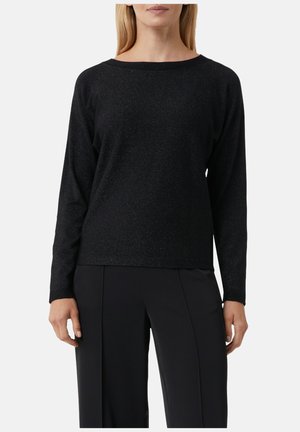 Haut noir à manches longues avec une coupe décontractée, une texture douce et un léger éclat. Encolure bateau, design simple, associé à un pantalon noir.