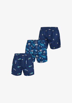 Trois paires de boxers bleu marine avec différents motifs : des baskets vertes, des palmiers tropicaux et des canards colvert.
