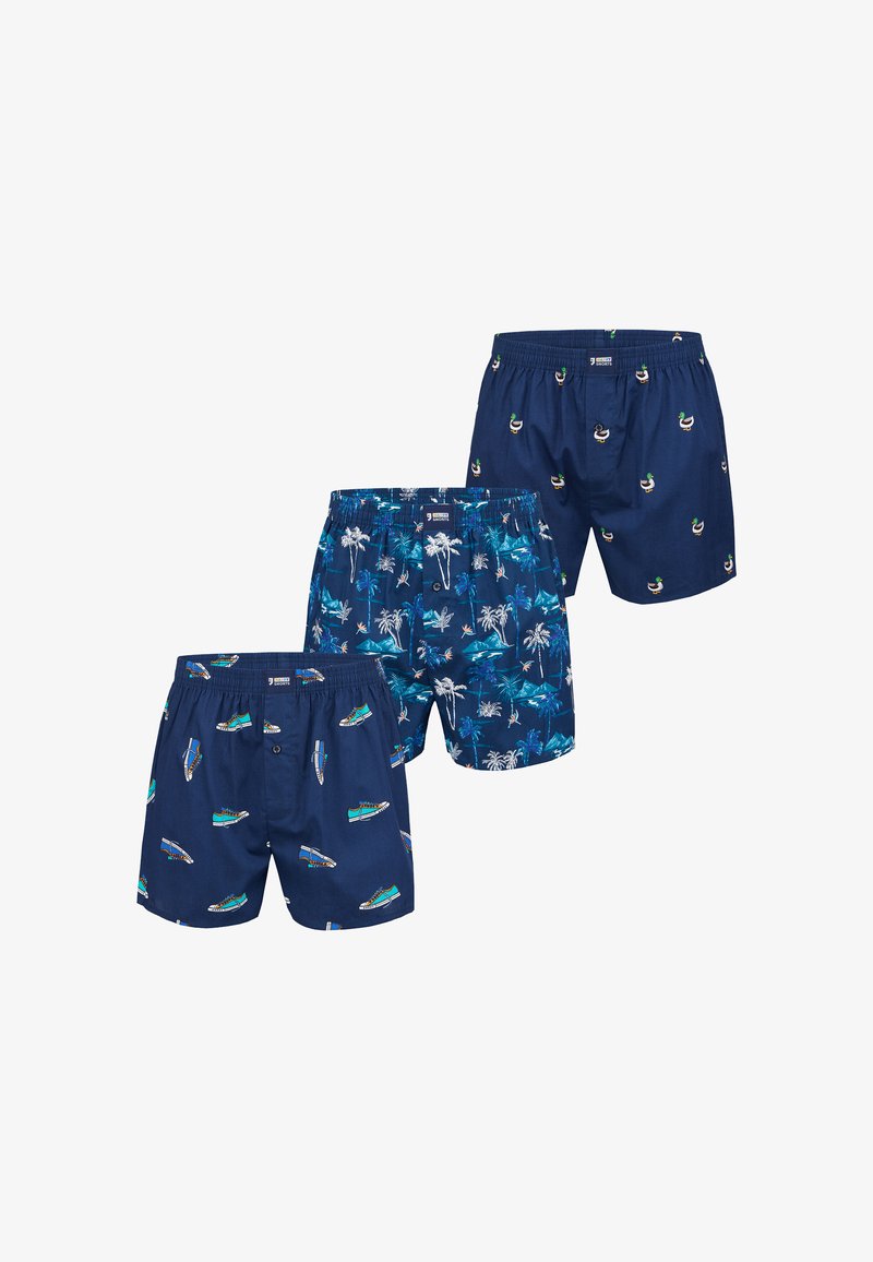 Tre paia di boxer blu navy con stampe diverse: scarpe da ginnastica verdi, palme tropicali e anatre mandarine.