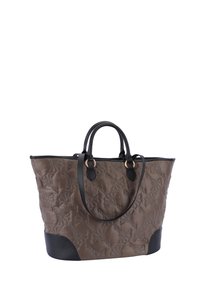 Ruskea päällystetty kantokassi mustilla nahkaosilla, kaksinkertaiset kahvat ja koristeellinen ommeltu kuvio, jossa on tilava aukko ylhäällä.