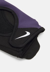 Accessorio Nike in tessuto nero e viola, con un design elegante, superficie testurizzata e logo bianco prominente. Bordo curvo e dettagli di cucitura.