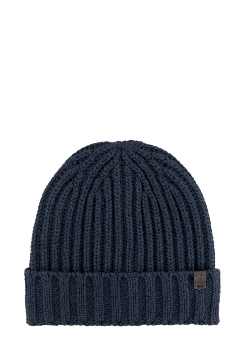 Marine gebreide beanie muts met ribbelstructuur, voorzien van een opgevouwen rand en een klein merklabel aan de zijkant.