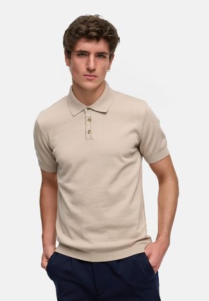 Beige kortermet polo skjorte med ribbet krage og tre knapper. Glatt tekstur med tettsittende design.