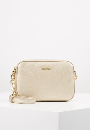 Sac bandoulière rectangulaire beige texturé avec bandoulière chaîne dorée et logo "HUGO" embossé en or sur le devant.