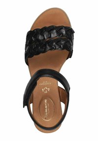 Sandalo in pelle nera con cinturini intrecciati, design con tallone chiuso, soletta testurizzata e suola marrone chiaro. Presenta il logo stampato sulla soletta.
