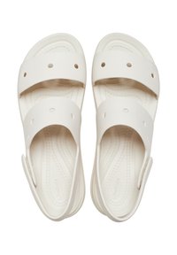 White sandals with two wide straps, featuring circular cutouts, textured footbed, and a molded design for comfort.