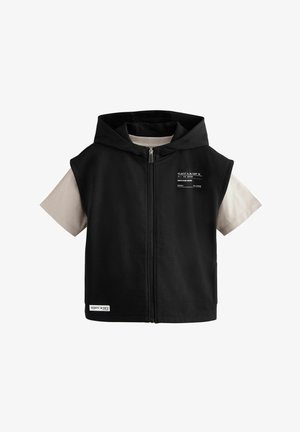 Schwarzes ärmelloses Hoodie mit einem vorderen Reißverschluss. Enthält eine hellbeige Kurzarm-Innenlage. Mit aufgedrucktem Text und einem Etikett am unteren Ende.