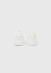 White platform sneakers with smooth texture, rounded shape, and minimal detailing on the back. Constructed with a rubber sole.