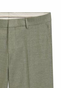 Jasnozielone spodnie o dopasowanym kroju, wykonane z teksturowanej tkaniny. Posiadają płaski przód, szlufki na pasek i kieszenie boczne.