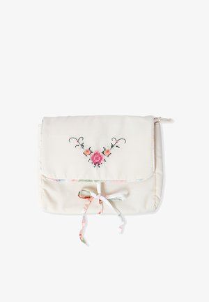 Crèmekleurig stoffen zakje met een bloemrijk kruissteekpatroon op de klep en een gestrikt lintje als sluiting in het midden vooraan.