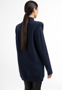Pulover supradimensionat de culoare bleumarin, fabricat dintr-un material moale, cu un guler înalt, manșete și tiv cu nervuri, evidențiind o siluetă lejeră.