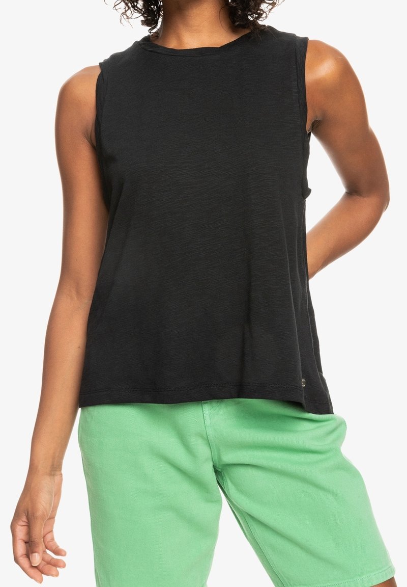 Top sans manches noir à coupe décontractée, fabriqué en tissu texturé. Assorti à un short vert. Encolure ras du cou simple, sans embellissements visibles.