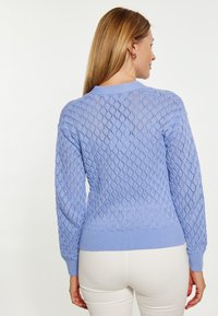 Pulover tricotat de culoare albastru deschis, cu un model în diamant, manșete și tiv cu nervuri, având un guler rotund și o finisare texturată.