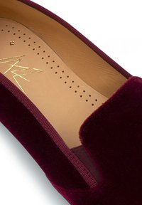 Bordeaux fluwelen instap schoen met een glad interieur, elastische zijkanten en een ronde neus. Geaccentueerd met een gouden logo op de binnenzool.