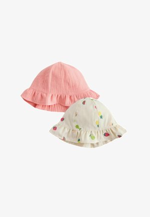 Dos gorros para niños pequeños: un gorro de algodón rosa texturizado con un borde fruncido y un gorro blanco con patrones de frutas bordadas y un borde fruncido.