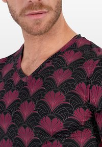 T-shirt à col en V en tissu noir avec un motif répétitif de fans roses et dorés ; texture douce avec une coupe ajustée.