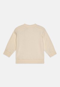 Ljusbeige sweatshirt med rund hals, långa ärmar och ribbade cuffs. Slät textur med en enkel design, med insydda ärmar.