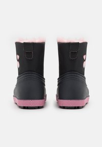 Bottes imperméables noires avec une bordure en fausse fourrure rose, ornées de motifs en forme de cœur et d'accents roses sur la semelle et les coutures. Semelle extérieure en caoutchouc texturée.