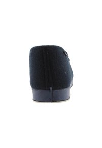 Zapatilla de lana azul oscuro con una textura suave, forma redondeada y suela de goma. Presenta un pequeño botón decorativo en el lateral.