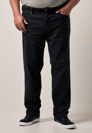 Pantalones azul marino de mezcla de algodón, con un corte recto, bolsillos laterales y cierre de botón. Combinados con zapatillas oscuras.
