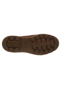 Braune Gummisohle mit strukturierter Grip-Oberfläche. Verfügt über ausgeprägte Lugs für optimale Traktion. Gestempeltes Logo in der Nähe der Ferse.