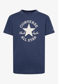 Tengerészkék pamut póló, fehér kör alakú grafikával, benne egy csillag és a "Converse Chuck Taylor All Star" felirat vastag betűkkel.