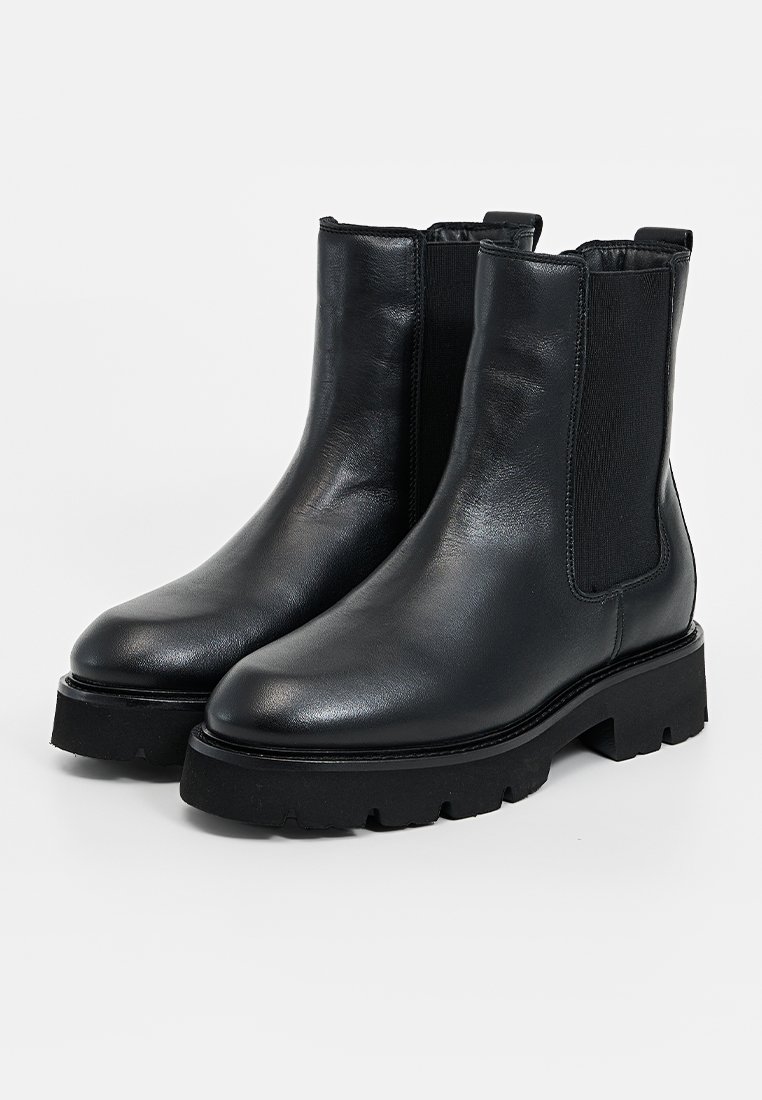 Schwarze Lederstiefeletten mit elastischen Seiteneinsätzen, robuster schwarzer Sohle und glatter Textur. Elegantes, minimalistisches Design.