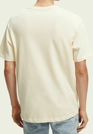 Kortærmet t-shirt i cremefarve lavet af blød bomuld. Løs pasform, rund halsudskæring og ren kant, med et minimalistisk design på ryggen.