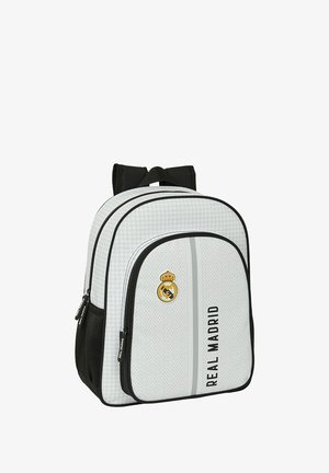Sac à dos blanc avec des accents noirs, présentant un motif texturé, le logo du Real Madrid, des compartiments à double zip et des bretelles réglables.