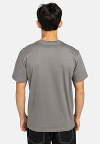 Graues Baumwoll-T-Shirt mit Rundhalsausschnitt und kurzen Ärmeln, mit einer glatten Textur und minimal sichtbaren Nähten am Saum.