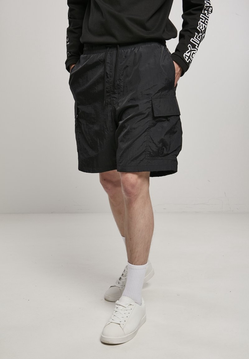 Shorts cargo noirs en tissu léger, avec une taille élastique, des poches latérales et une grande poche cargo sur la cuisse.