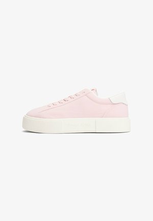 Helle rosa Sneaker mit einem glatten Stoff-Obermaterial, weißen Fersenelementen, flachen Schnürsenkeln und einer dicken weißen strukturierten Sohle. "TOMMY JEANS" Logo an der Seite.