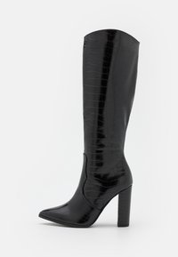 Bottes noires à hauteur du genou avec un bout pointu et un talon carré, présentant une texture brillante au motif crocodile et une finition lisse.