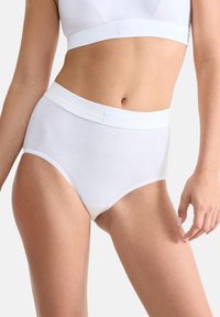 Witte katoenen hoge tailleslip met een gladde textuur, elastische tailleband en geschulpte beenopeningen, ontworpen voor comfort en dekking.