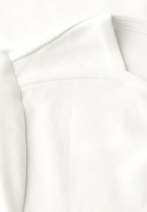 Tessuto di cotone bianco con una superficie liscia e leggermente lucida, stratificato con un bordo piegato e dettagli di cucitura visibili.