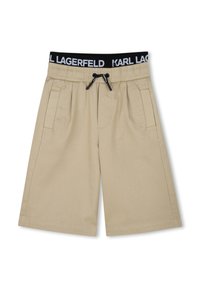 Beige shorts met een elastische zwarte tailleband gelabeld "KARL LAGERFELD," trekkoordsluiting en twee zijzakken.