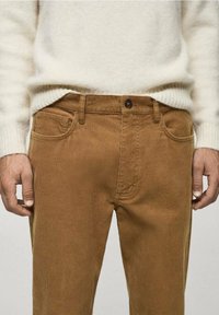 Hnědé kordové kalhoty slim fit s dvěma předními kapsami, zapínáním na knoflík a texturovanou střižní tkaninou.