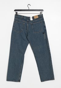Vaqueros de denim azul con pierna recta, diseño de cinco bolsillos y una etiqueta de cuero en la cintura. Presenta una etiqueta de cuidado en el costado.