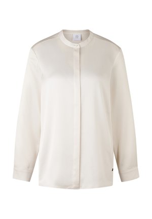 Cremefarvet langærmet skjorte med kinesisk krave, knaplukning, glat tekstur og en subtil glans. Har en side-label accent.