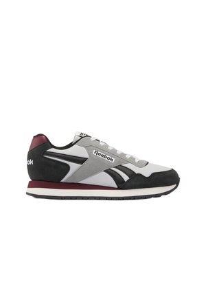 Zapatilla baja Reebok en blanco, negro, gris y granate con cierre de cordones y logo de la marca en el lateral y el talón.