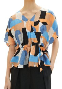 Top a maniche corte, avvolgente, in tessuto leggero che presenta un mix di motivi geometrici blu, arancioni, neri e bianchi, con vita arricciata e dettaglio di legatura.