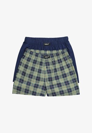 Dos pares de bóxers para hombre: uno de algodón azul marino con cintura elástica, otro a cuadros con colores verde, azul marino y naranja. Ambos tienen etiquetas de la marca.