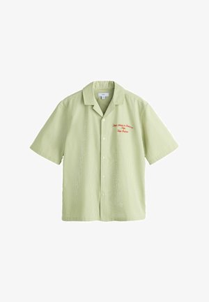 Lysegrøn kortærmet skjorte med knapper, tynde lodrette striber og rød broderet tekst på venstre bryst.